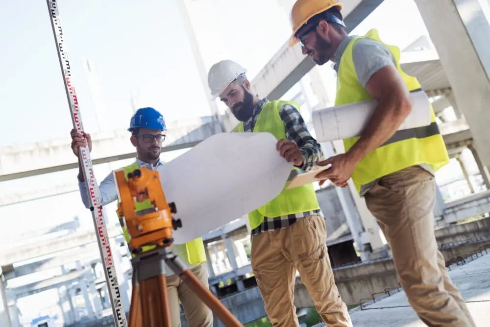 Group of engineers in a construction looking at a blue print - for the construction recruitment services page